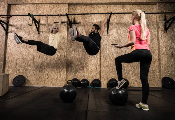 Sportovní Fitness lidé skupina dělá Pull Ups na vodorovný pruh Crossfit tréninku, trenér mladé zdravé ženy — Stock fotografie