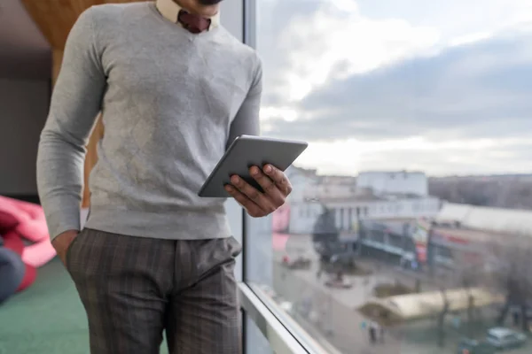 Hispanic Business Man Using Tablet Computer Stand in front Panoramic Window Businessman In Coworking Center