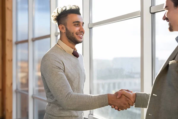 Twee Man Shake Hand overeenkomst naaiatelier zakencentrum Business Team collega's staan op de voorgrond groot panoramisch venster — Stockfoto