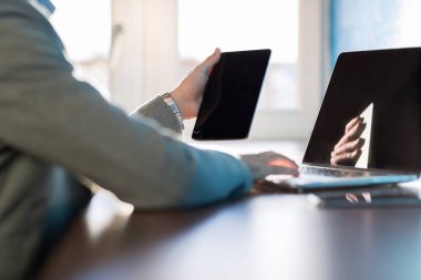 Tablet ve işadamı oturma Resepsiyon Coworking merkezi çalışma tipik dizüstü bilgisayar kullanarak iş adamı