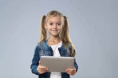 Küçük genç kız kullanarak Tablet bilgisayar, küçük mutlu gülümseyen çocuk evlat