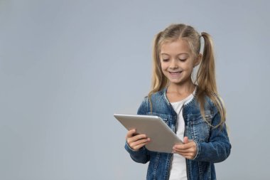 Küçük genç kız kullanarak Tablet bilgisayar, küçük mutlu gülümseyen çocuk evlat
