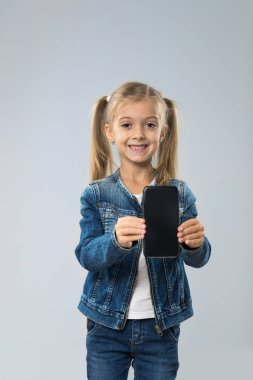 Küçük genç kız gösteri hücre akıllı telefon ekran boş kopya alanı ile küçük çocuk mutlu gülümseyen çocuk