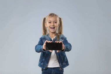 Küçük genç kız gösteri hücre akıllı telefon ekran boş kopya alanı ile küçük heyecanlı mutlu gülen çocuk