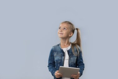 Güzel küçük kız mutlu gülümseyen izole kopya alanı ararken Tablet bilgisayar kullanarak