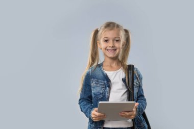 İzole Tablet bilgisayar mutlu gülümseyerek aşınma Kot ceket kullanan güzel küçük kız
