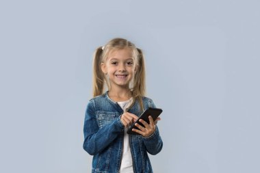 Güzel küçük kız hücre kullanarak akıllı izole telefon mutlu gülümseyerek aşınma Kot ceket
