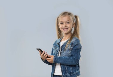 Güzel küçük kız hücre kullanarak akıllı izole telefon mutlu gülümseyerek aşınma Kot ceket