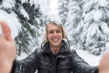 Selfie fotoğrafta kış kar orman adam havada gülümseme kamera genç adam
