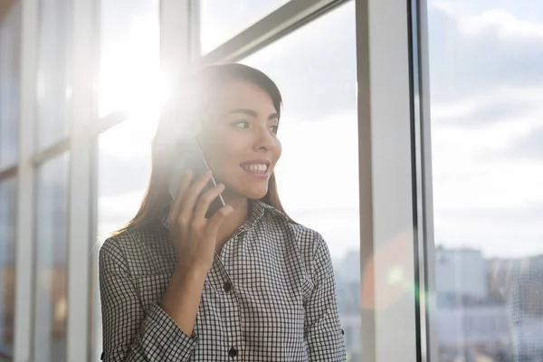 Asya iş kadın konuşmak üzerinde cep telefonu aramak ayakta ön panoramik pencere işkadını içinde Coworking Merkezi — Stok fotoğraf