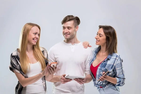 Casual mensen groep, jonge Man twee vrouw tevreden glimlach met behulp van cel slimme telefoon netwerkcommunicatie — Stockfoto