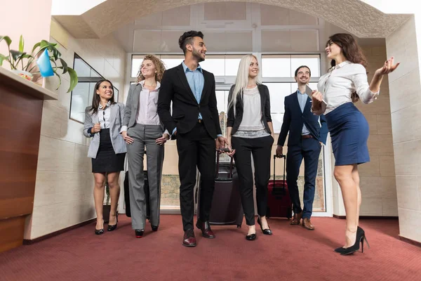 Hotel Receptionist Meeting Business People Group In Lobby