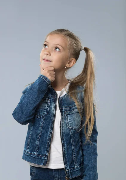 Küçük genç kız Kot ceket, küçük çocuk kopya uzay düşünmek için ararken tutun çene — Stok fotoğraf