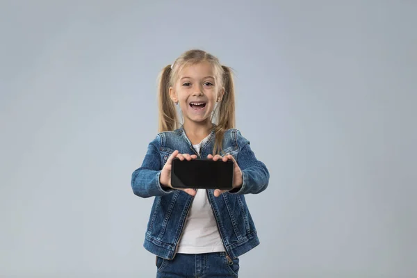 Małe komórki Pokaż nastolatkę inteligentny telefon z puste miejsce, małe podekscytowany szczęśliwy uśmiechający się dziecko — Zdjęcie stockowe