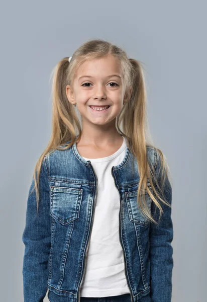 Śliczną dziewczynkę szczęśliwy uśmiechający się nosić dżinsy płaszcz na białym tle — Zdjęcie stockowe