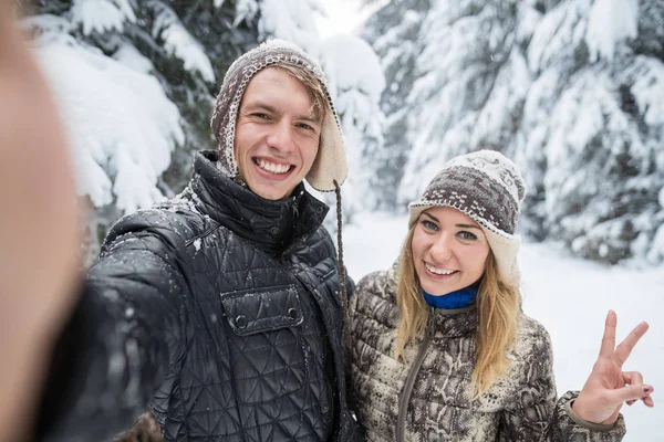 Az ember vesz Selfie fénykép fiatal romantikus pár mosoly hó erdő szabadtéri — Stock Fotó