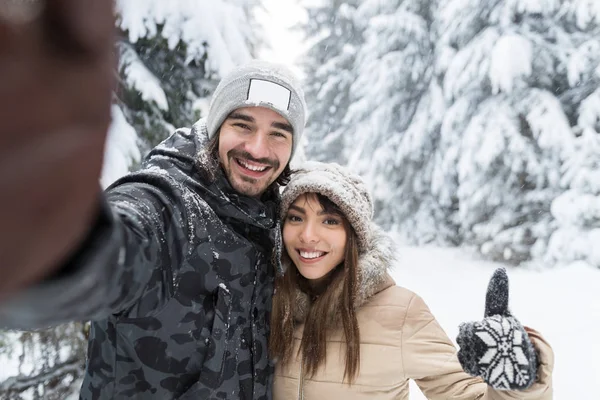 Az ember vesz Selfie fénykép fiatal romantikus pár mosoly hó erdő szabadtéri — Stock Fotó