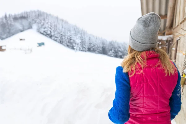 Menina olhando para neve nevado inverno floresta Viggale madeira casa de campo Resort Cottage — Fotografia de Stock