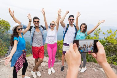 Peyzaj üzerinde dağ yukarıdan poz insanlar fotoğrafta sırt çantası ile neşeli turist grubunun akıllı telefon