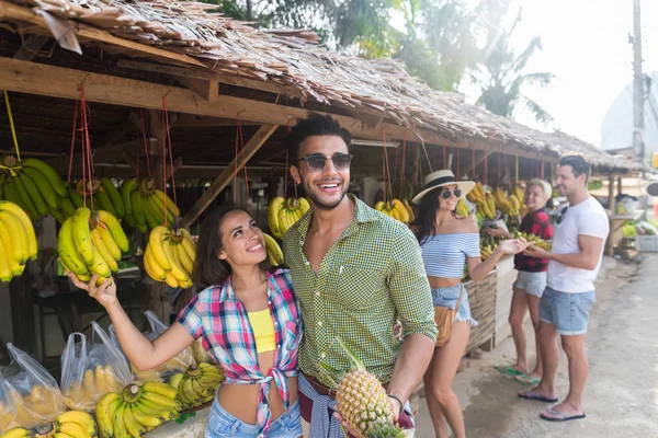 Kopen van bananen op traditionele straatmarkt, jonge Man en vrouw reizigers (echt) paar — Stockfoto