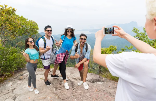 Chytrý mobil Foto veselá turistické skupiny s batohem převzetí krajina hory shora, lidé představují — Stock fotografie