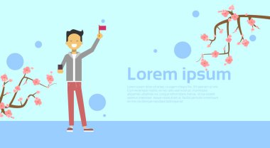 Asyalı erkek Sakura Cherry Blossom ile kopya alan arka plan üzerinde bayrak tutan