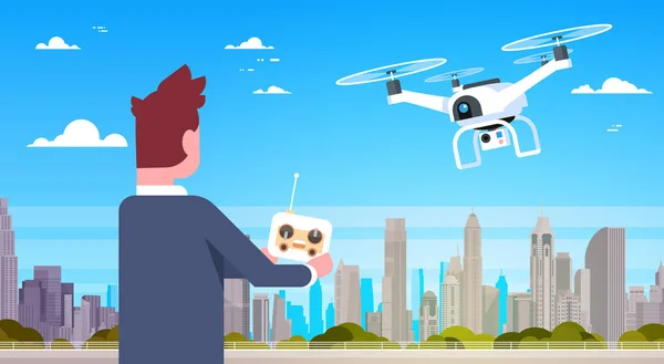 O homem de negócios que prende o controlador remoto para o drone moderno voa sobre edifícios da cidade —  Vetores de Stock