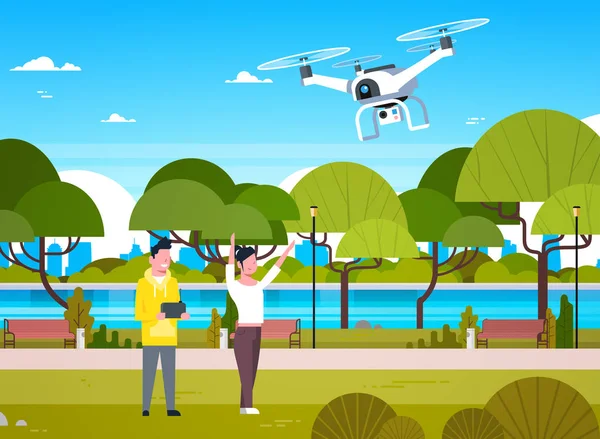 I giovani che giocano con l'elicottero del drone nell'uomo e nella donna del parco usando il telecomando per quadrocopter — Vettoriale Stock