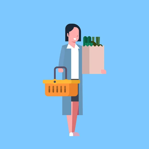 Mladá žena nakupování hospodářství papírový pytlík a košík plný potravinářských produktů — Stockový vektor