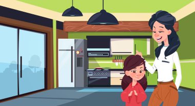 Anne ve kızı buzdolabı ve soba arka plan üzerinde Modern mutfak