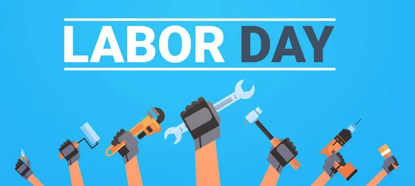 Cartaz do dia do trabalho com as mãos segurando diferentes instrumentos fundo Trabalhadores feriado Banner Design — Vetor de Stock