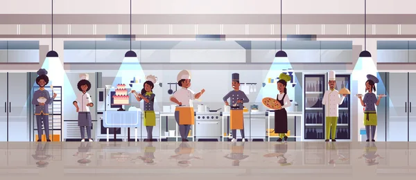 Diferentes chefs de pie juntos afroamericanos hombres mujeres r en uniforme cocina comida concepto moderno restaurante cocina interior plano longitud completa horizontal — Vector de stock