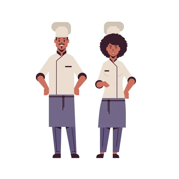 Cocina pareja profesional chefs de pie junto africano americano hombre mujer restaurante cocina trabajadores en uniforme cocina concepto de comida plana longitud completa — Vector de stock