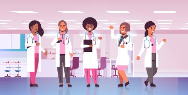 Göğüs kanseri günü doktorları pembe kurdeleli paltolar giyiyorlar yarış hastanesi meslektaşları hastalık bilinci ve önleme konsepti düz yatay