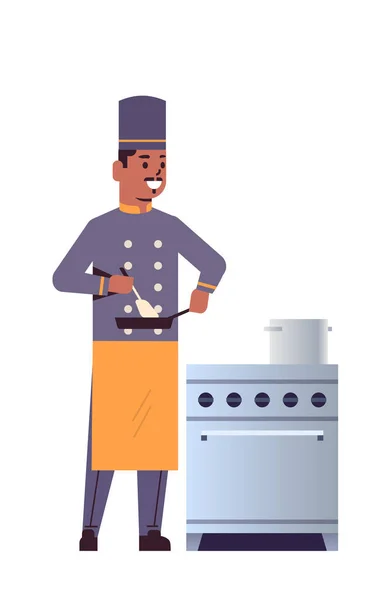 Chef profesional masculino que usa sartén revolviendo comida hombre afroamericano trabajador de cocina de restaurante en uniforme de pie cerca de la estufa concepto de cocina plana de longitud completa vertical — Vector de stock