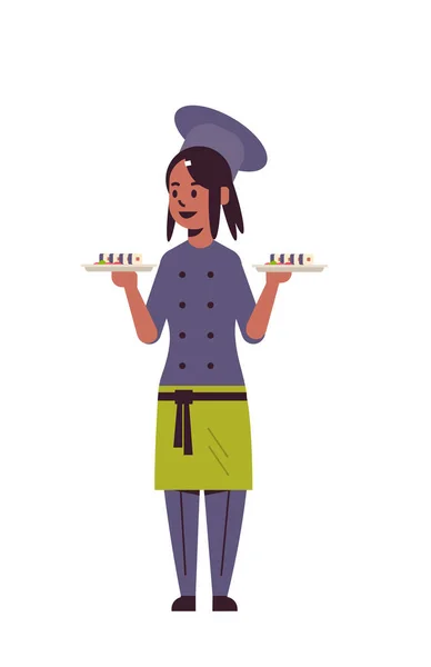 Cocinera cocinera sosteniendo bandejas con rollos de sushi fresco mujer afroamericana trabajadora de cocina de restaurante en uniforme llevando bandeja con concepto de cocina de comida tradicional japonesa de longitud completa vertical — Vector de stock
