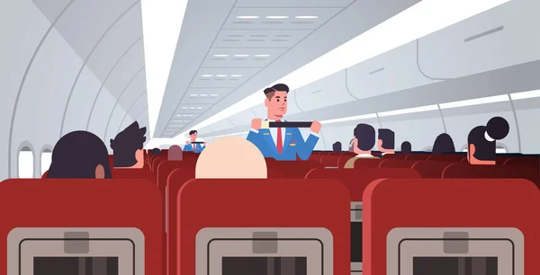 乘务员向乘客解释如何在紧急情况下使用安全带系紧男乘务员在制服安全示范概念中的应用现代飞机内水平飞行 — 图库矢量图片