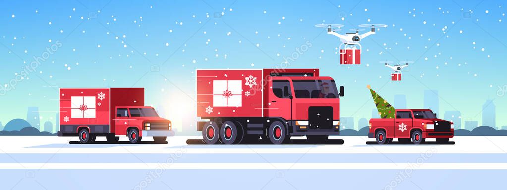 trucks pickup car driving road quadcopters with gift boxes delivery shipping transport merry christmas happy new year winter holidays concept horizontal snowy cityscape background
