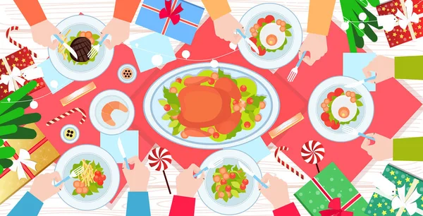 Hands holding fork and knife eating food on christmas new year dinner table roast duck and side dishes winter holiday celebration concept top angle view horizontal — Stock Vector