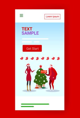 Adam hediye kutusunu kadınlara veriyor mutlu noeller Noel kutlaması konsepti Noel baba şapkalı çift uygun ağaç ekranlı akıllı telefon uygulaması tam boy mobil uygulama
