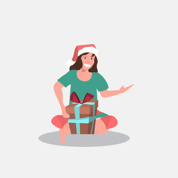 Frau in Weihnachtsmann Hut sitzend mit Geschenkbox Frohe Weihnachten Frohes Neues Jahr Winterurlaub Feier Konzept volle Länge — Stockvektor