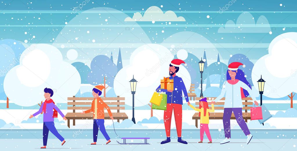 family in santa hats walking outdoor parents holding shopping bags children having fun christmas sale winter holidays concept urban snowy park landscape horizontal full length