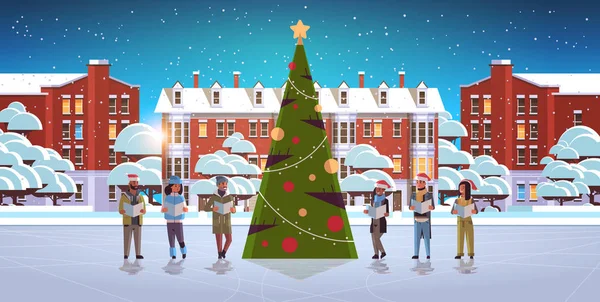 Mix závod lidé čtení knihy veselé Vánoce šťastný nový rok dovolená koncepce muži ženy nosí Santa klobouky stojící v blízkosti fit strom moderní město pozadí horizontální plné délky — Stockový vektor