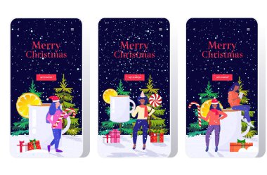 Noel 'e yakın şeker tutan kızlar sıcak şarap içer kış tatili kutlaması konsepti akıllı telefon ekranları çevrimiçi mobil uygulama tam uzunlukta tebrik kartı yatay