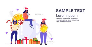 Noel 'e yakın insanlar ellerinde şeker kamışı lolipopu ve portakal dilimli kış tatili kutlaması konsepti yatay fotokopi alanı konsepti ile sıcak şarap içerler.