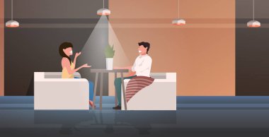 Kafe masasında oturan mutlu erkek kadın romantik randevu konseptini tartışıyor modern restoran iç mekan tam boy