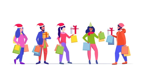 Misturar pessoas de raça em chapéus de santa levando sacos de compras e presentes caixas de Feliz Natal feliz ano novo inverno feriados celebração conceito completo comprimento esboço horizontal —  Vetores de Stock