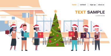 Noel ağacının yanında duran yarış öğrencilerini Noel Baba şapkalarıyla karıştıran okul çocukları yılbaşı kutlaması konsepti modern sınıf içi tam boy yatay fotokopi alanı.