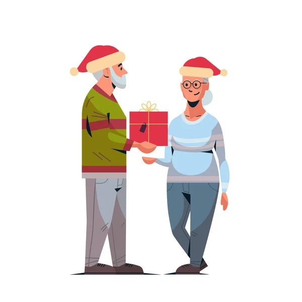 Senior homme en santa chapeau donnant cadeau boîte à mature femme famille célébrant joyeux Noël bonne année vacances d'hiver concept pleine longueur — Image vectorielle