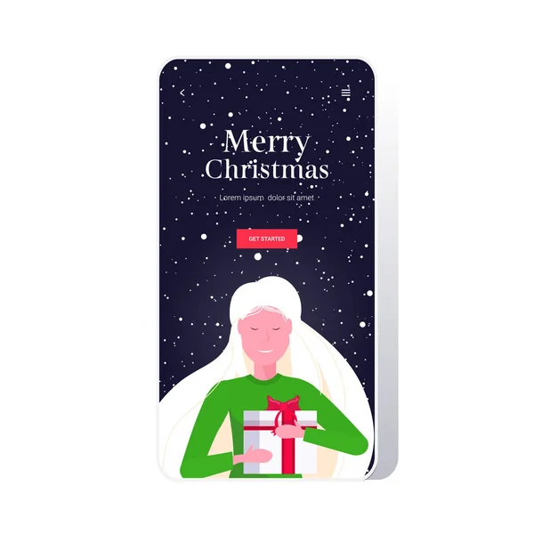 Mujer sonriente sosteniendo envuelto caja de regalo Feliz Navidad feliz año nuevo vacaciones de invierno celebración concepto tarjeta de felicitación retrato smartphone pantalla aplicación móvil en línea — Vector de stock